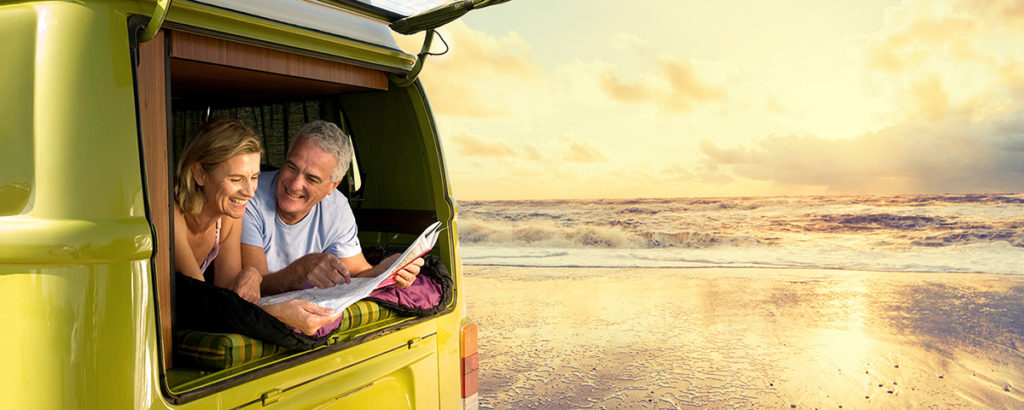 older couple in a van by the sea